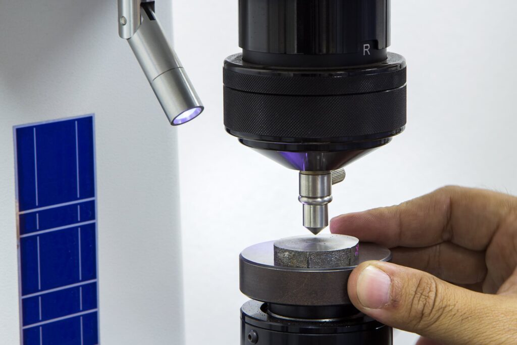 Operator inspecting material hardness using a Rockwell hardness tester