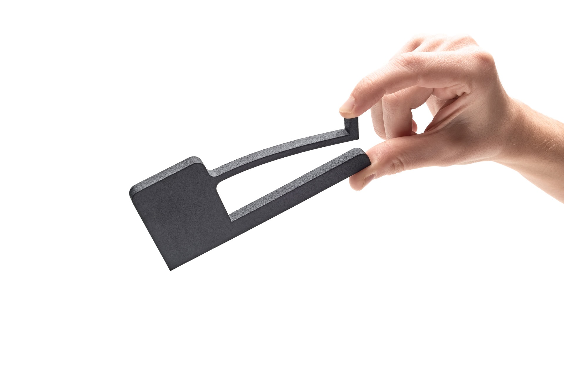 Hand bending a flexible 3D-printed plastic part to demonstrate material flexibility