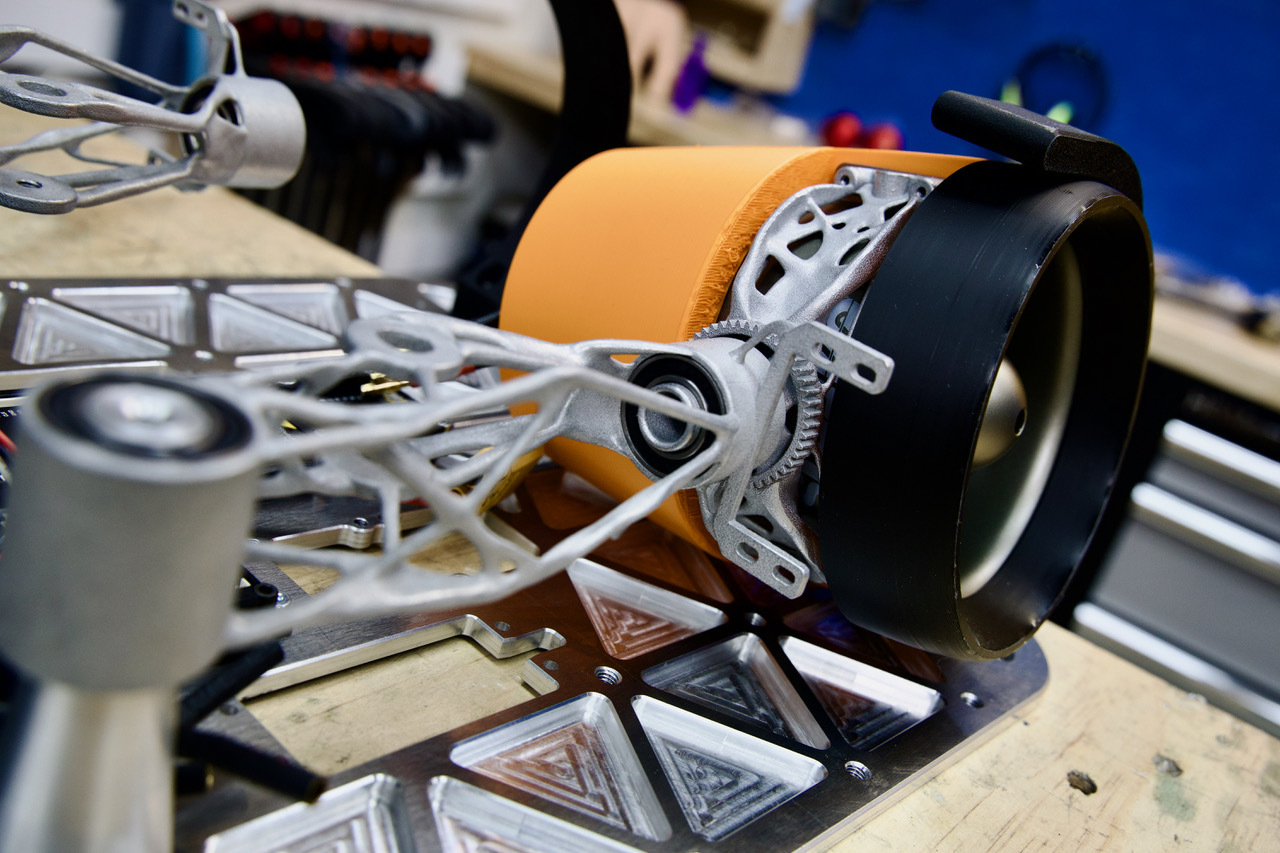3D-printed metal parts being fitted into the booster backpack’s deployable arm system